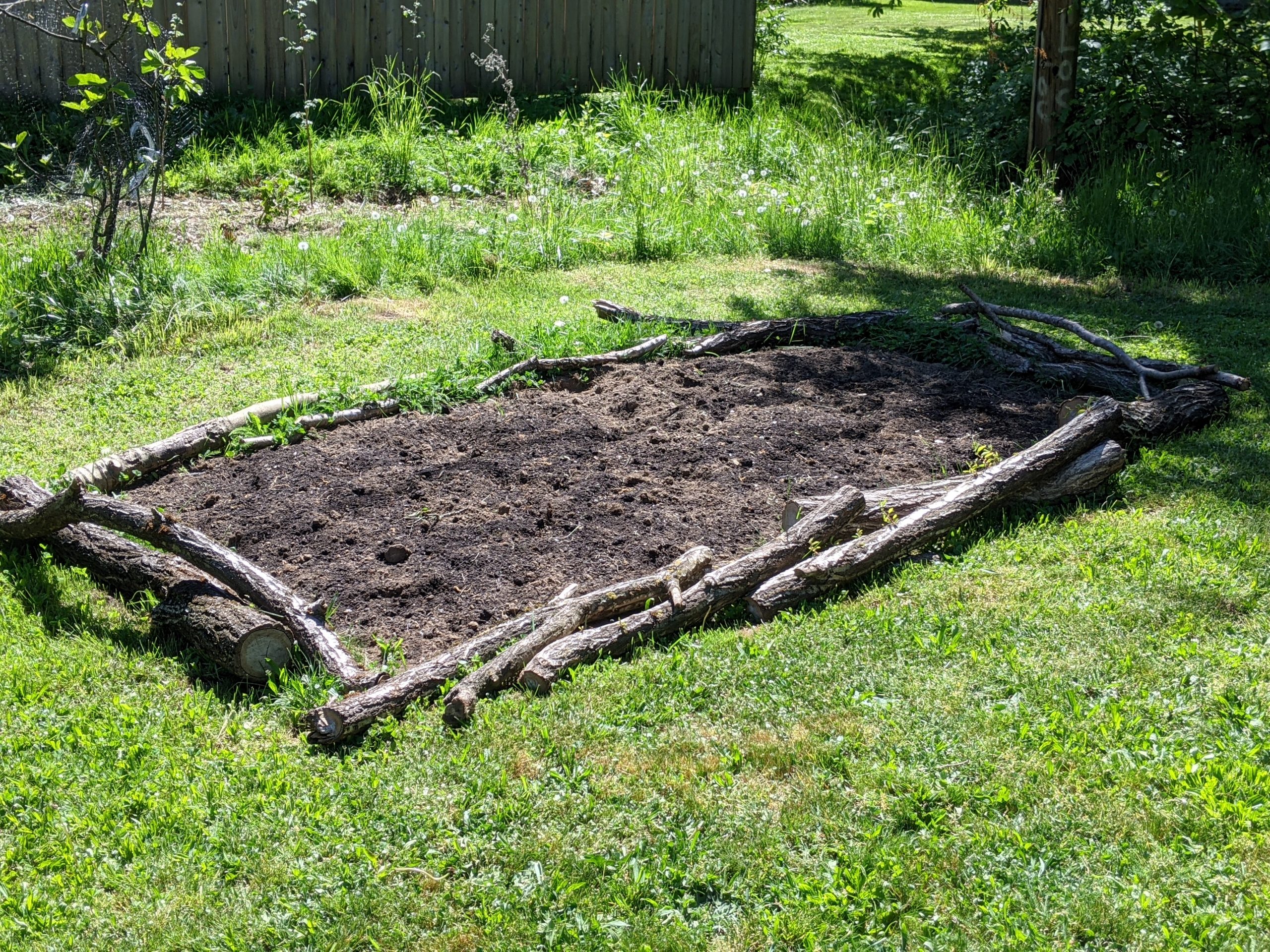 Logs and branches line this garden bed
